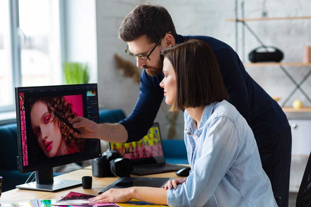 ADS female and male graphic designers working on computer 350359628 Curve Content