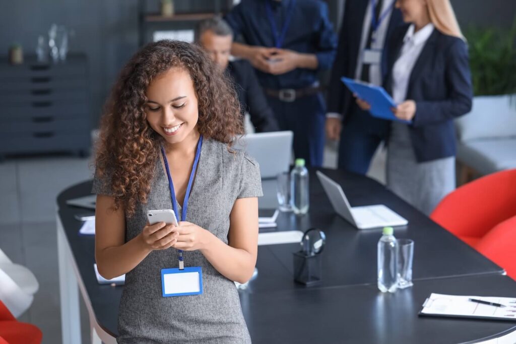 ad young woman smiling at mobile phone in business office compressed Curve Content
