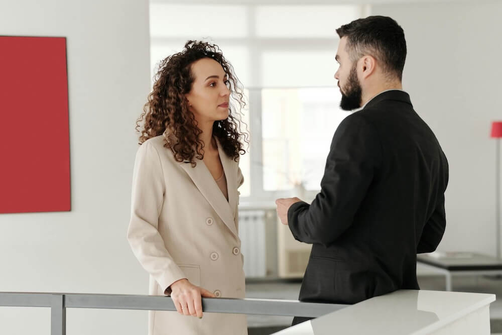 co workers standing in office compressed Curve Content